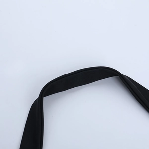 Détail de la bandoulière en tissu noir et des coutures du haut de corset en dentelle