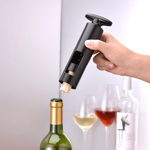 Manual black waiter's corkscrew opening a wine bottle in a professional kitchen setting