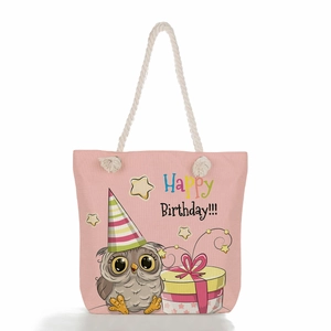Pink canvas tote bag with cute owl birthday print and beige rope handles on white background