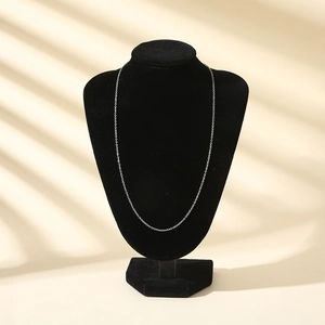 Sleek silver chain necklace displayed on a black velvet mannequin with natural lighting