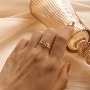 Close-up of S925 silver ring with purple floral stones and gold finish on finger
