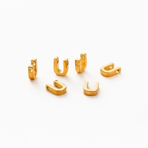 Macro detail of 6 golden vacuum plated U-shaped letter connectors for DIY jewelry