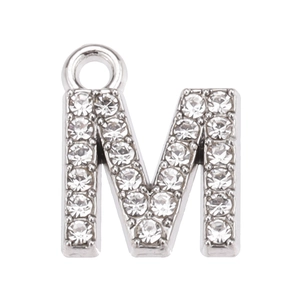 Detail of silver letter M pendant encrusted with sparkling white rhinestones for jewelry