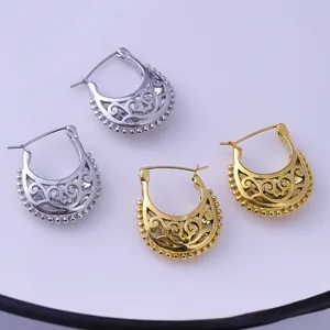 Detailed macro view of gold and silver horseshoe earrings with intricate filigree patterns