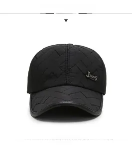 Detail of black quilted baseball cap featuring a metal JEANS logo and diamond pattern