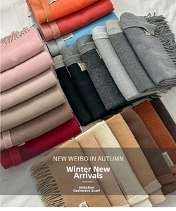 Close-up of stacked cashmere-like scarves featuring elegant tassels and branded woven labels