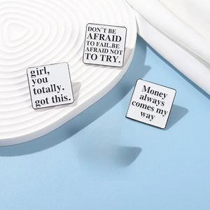 Detail of four square enamel pins featuring black inspirational quotes on white background