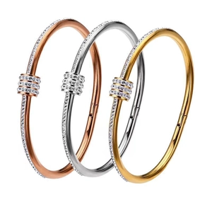 Three minimalist stainless steel bangles in rose gold, silver and gold with diamond accents
