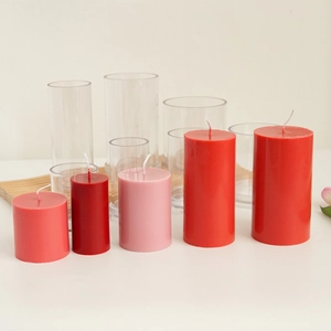 Red and pink pillar candles of various sizes displayed on a wooden base for DIY decor