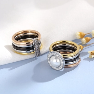 Macro detail of multi-layered stackable rings with sparkling zircon bars and a round pearl