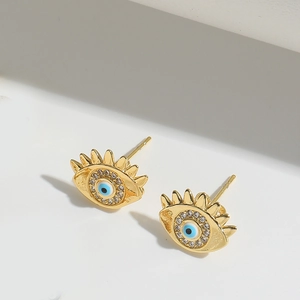 Detailed macro view of gold Evil Eye earrings with blue center and white zircon stones