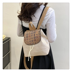 Detail of woven straw backpack with vintage patterned flap and drawstring closure
