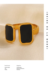 Macro detail of gold-plated geometric square ring with black enamel on champagne silk