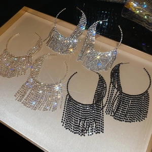 Macro shot of sparkling rhinestone fringe hoop earrings in gold, silver, and black tones