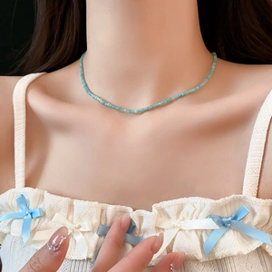 Gros plan d'un collier de perles bleues sur un mannequin montrant de fins cristaux