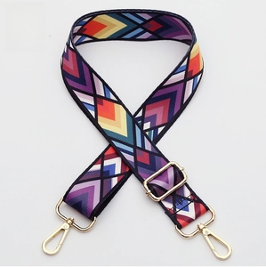 Detail of adjustable woven bag strap with colorful ethnic pattern and gold metal hooks