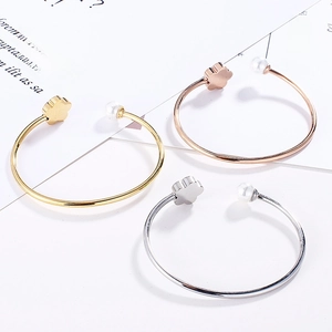 Detailed shot of open metal bangles featuring elegant pearls and flower accents