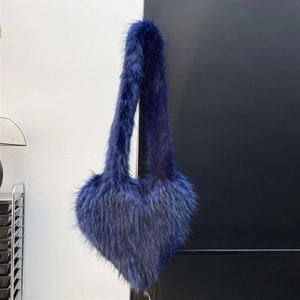 Close-up detail of dark blue heart-shaped faux fur bag with soft fluffy plush texture