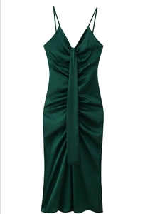 Détail d'une robe en satin vert foncé montrant le col en V élégant et le tissu froncé