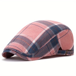Detail of pink and blue plaid newsboy cap featuring adjustable metal side buckle