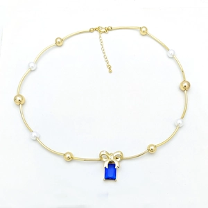 Detail of beaded choker necklace with white pearls and blue gemstone pendant