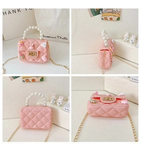 Detail of pink silicone mini bag with pearl handle and cartoon charms on diamond lattice