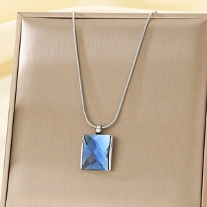 Detail of blue rectangular crystal pendant on a silver snake chain necklace