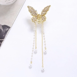 Golden crystal butterfly hair claw clip with pearl tassels on a clean white background