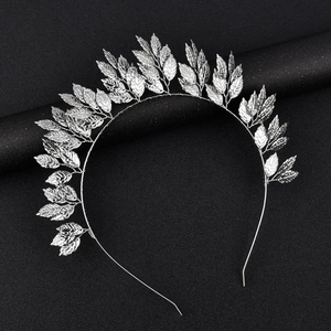 Detail of silver leaf headpiece showing intricate metal leaves on a dark background