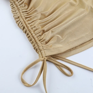 Dettaglio macro del tessuto elastico oro champagne con arricciature e coulisse
