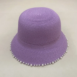 Detail shot of purple straw sun hat featuring elegant pearl trim on the woven brim edge