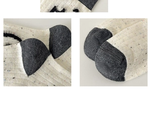 Detailed knit texture of off-white socks with colorful specks and dark gray contrast heel
