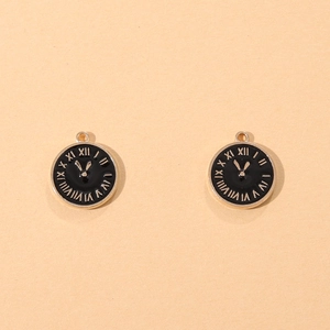 Golden clock pendants with black enamel and Roman numerals on beige textured background
