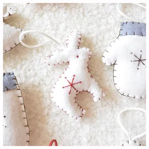 Close-up of handmade felt Christmas ornaments with grey stitching and snowflake embroidery