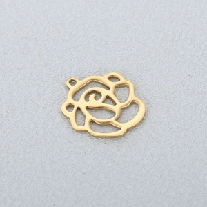 Gros plan d'un pendentif rose évidé en acier inoxydable doré avec finition polie
