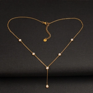 Elegant gold Y-shaped stainless steel necklace with sparkling crystal zircons on black background