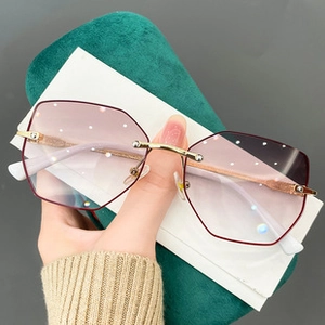 Detail der lila randlosen Katzenaugenbrille mit Diamantschliffkanten und Metallbügeln