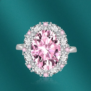 Top view of luxurious oval pink gemstone ring with halo diamonds on dark base