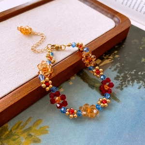 Détail du collier de fleurs fait main avec cristaux ambrés et bleus sur plateau bois