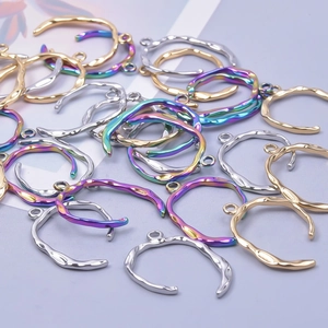 Detailed view of wavy irregular metal pendants in gold, silver, and rainbow plating