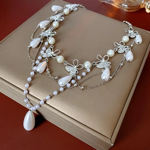 Detailed macro view of French vintage butterfly pearl necklace on a jewelry display box