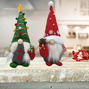 Détail de gnomes de Noël en peluche avec bonnets rouge et vert sur bois naturel