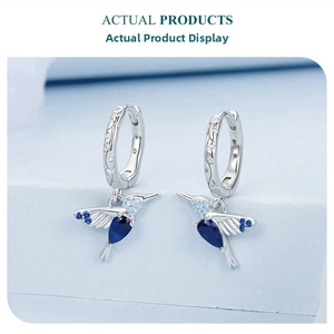 Detail of 925 sterling silver hummingbird earrings with blue gemstone inlay and micro-pave