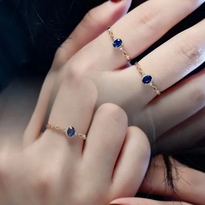 Macro shot of rose gold rings with oval blue sapphire and twisted rope band details
