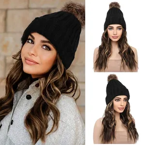 Detail of black ribbed knit beanie with brown faux fur pom and long wavy highlights hair