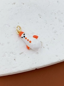 Detailed view of a cute snowman pendant on a stone slab with golden ring attachment