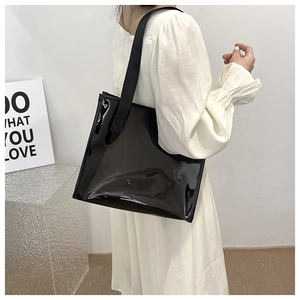 Large black transparent PVC tote bag shown from a side-view on a female model