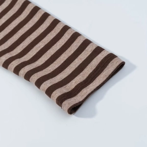 Primer plano de los puños a rayas con textura de punto acanalado marrón y beige
