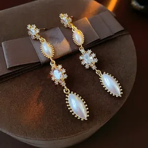 Vintage gold tassel earrings with marquise pearls and zircon set on dark velvet