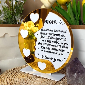 Detail of round golden mirror acrylic Mom plaque with floral decor and white base